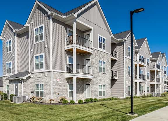 A row of modern apartment buildings with balconies and patios.