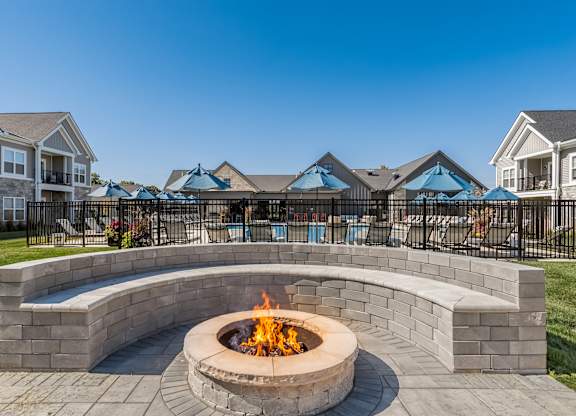A fire pit sits in the middle of a brick patio.