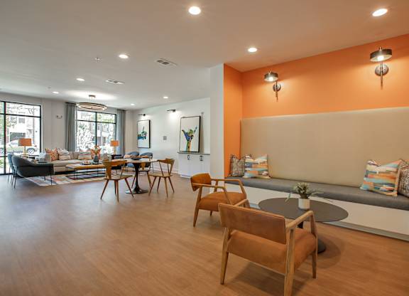 A living room with a grey couch and orange walls.