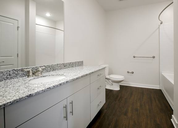 A bathroom with a toilet, sink, and a bathtub with a shower head.
