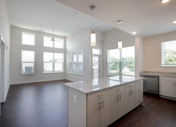 A kitchen with white cabinets and a large island.