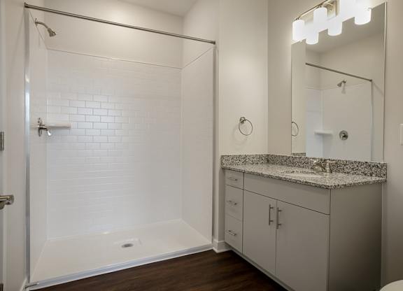 A white bathroom with a walk-in shower and a toilet.