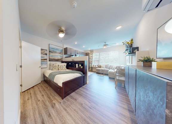 A bedroom with a bed, a chair, and a mirror.