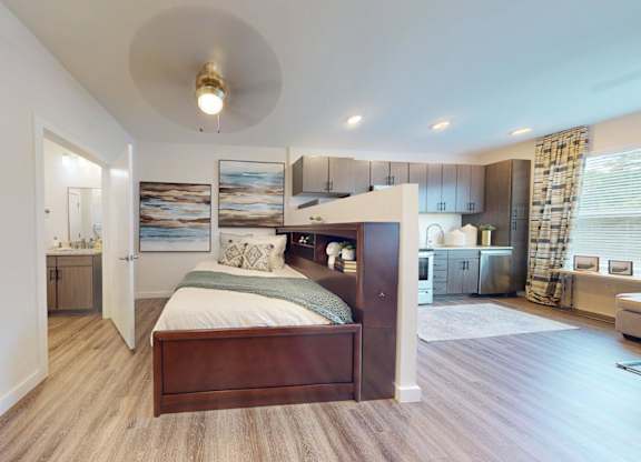 A bedroom with a large bed and a painting on the wall.