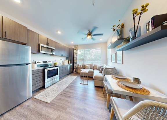 A modern kitchen with stainless steel appliances and wooden cabinets.