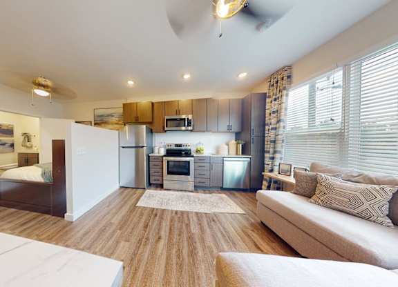 A modern living room with a white sofa and a wooden floor.