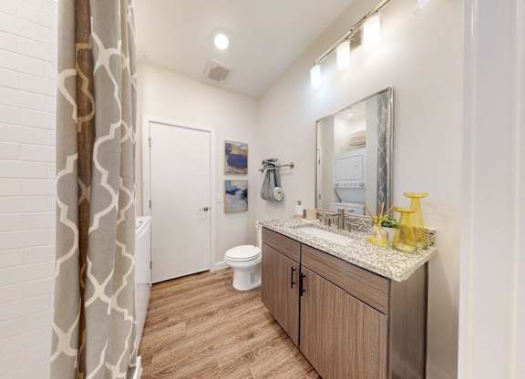 A bathroom with a wooden vanity and a white toilet.