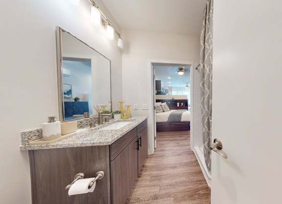 A bathroom with a marble countertop and a large mirror.