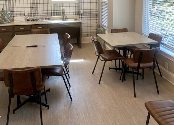 A kitchen with a table and chairs.