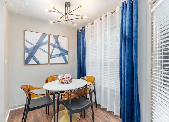 A dining room with a white table and chairs.