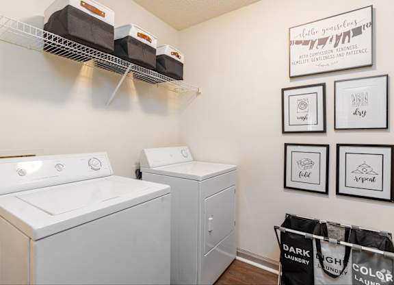 A laundry room with a washer and dryer and a sign that says