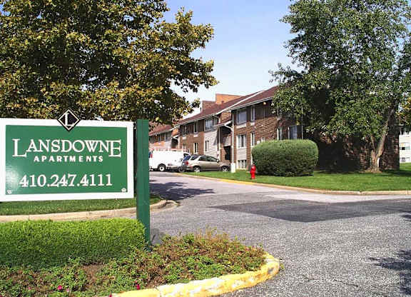 A green sign for Lansdowne Apartments with a phone number on it.