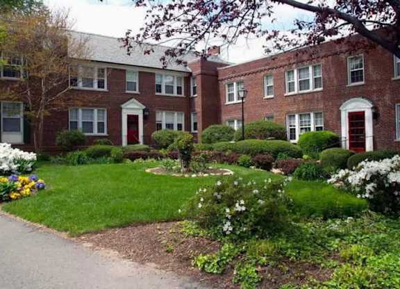 A red brick building with white trim and a green lawn in front.
