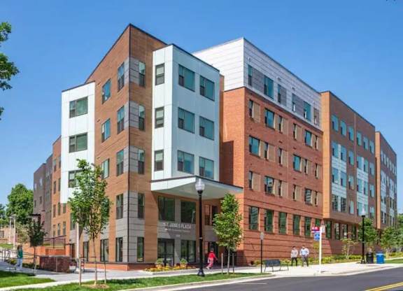 A modern multi-story building with a mix of brick and glass facade.