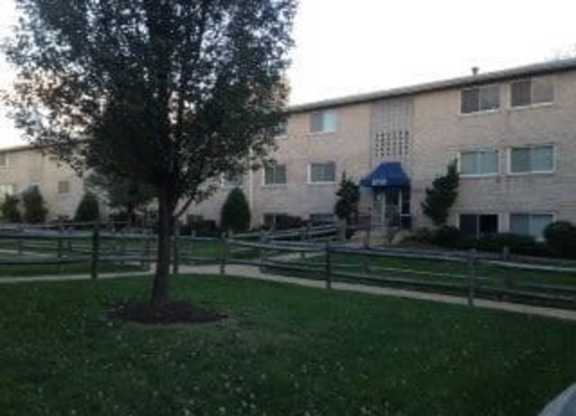 A tree in a grassy area in front of a building.