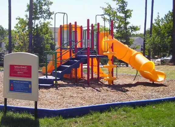 A playground with a yellow slide and a sign that says "Welcome".