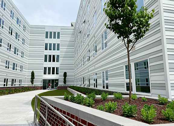 a view of the exterior of an apartment building with a garden