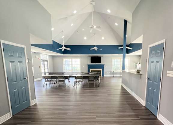 a large room with a table and chairs and a ceiling fan