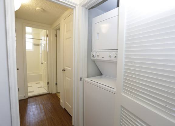 a laundry room with a washer and dryer and a door to a bathroom