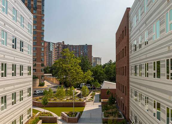 a view of a courtyard with buildings and grass