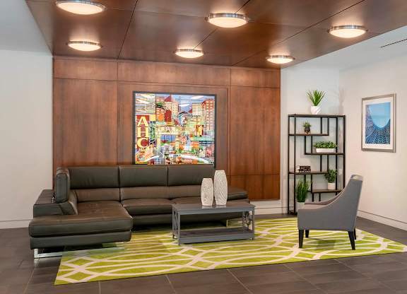 a lobby with couches and chairs and a painting on the wall