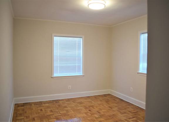 A room with a window and wooden flooring.