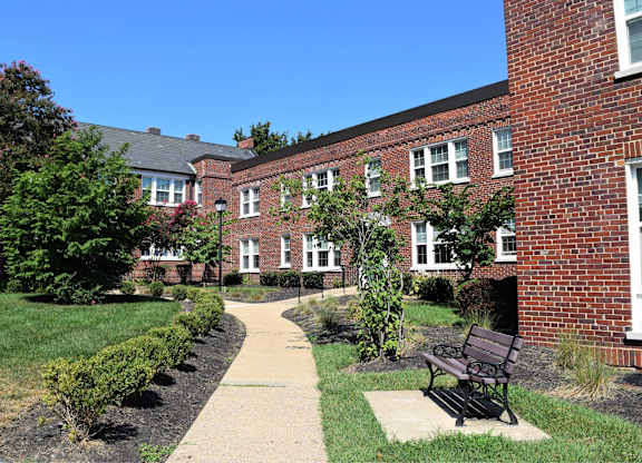 A brick building with a bench in front of it.