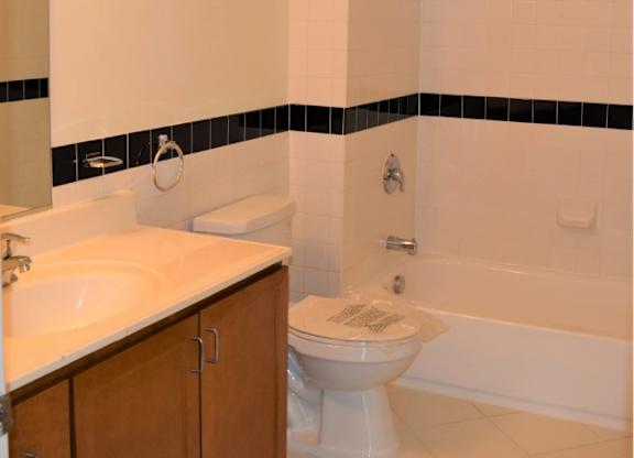 A white toilet with a white sink and a white bathtub in a bathroom.