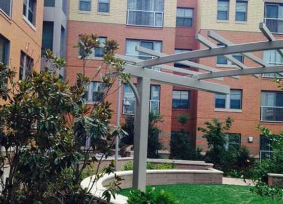 A patio with a table and chairs is in front of a building.