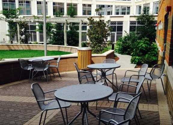 A patio with a table and chairs is surrounded by a brick wall.