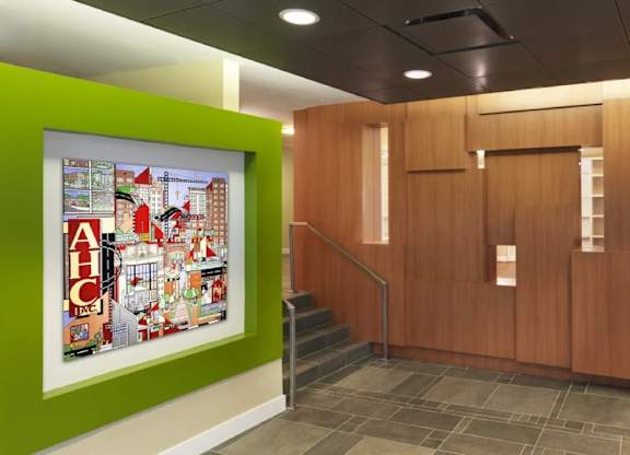 A hallway with a green wall and a painting of a cityscape with the letters AHC.