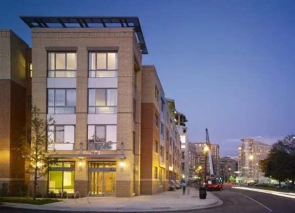 A modern building with a glass entrance and a lit up sign that says "The".