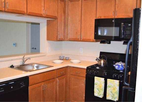 A kitchen with wooden cabinets and a black stove.