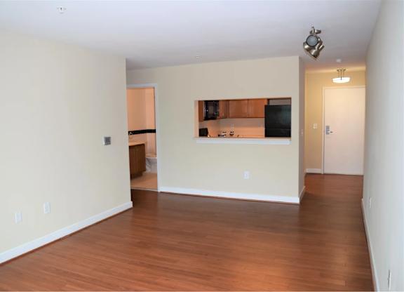 A room with wooden floors and a small kitchenette.