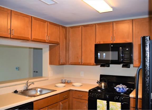 A kitchen with wooden cabinets and a black stove.