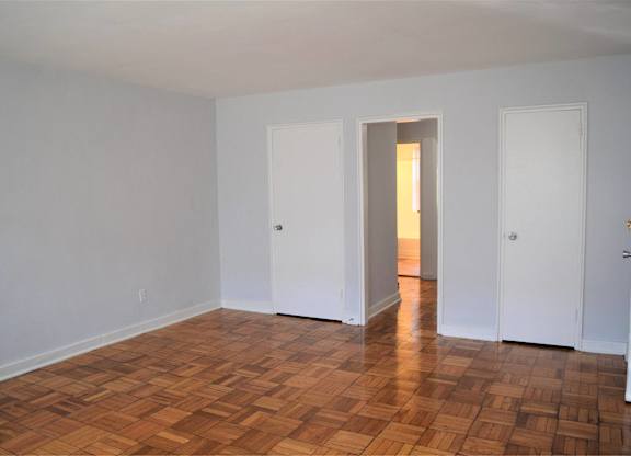 A room with wooden flooring and white walls.
