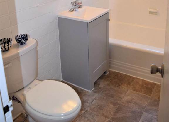 A white toilet sits next to a white sink in a bathroom.