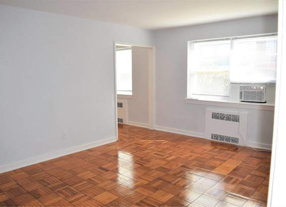 A room with a wooden floor and a window.