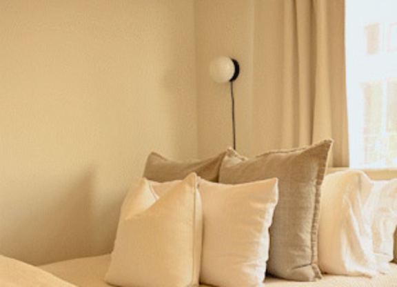 A bed with a white comforter and pillows.