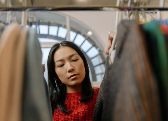 A woman is looking at clothes in a store.