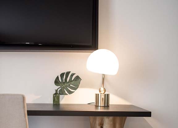 A desk with a chair and a lamp on it.