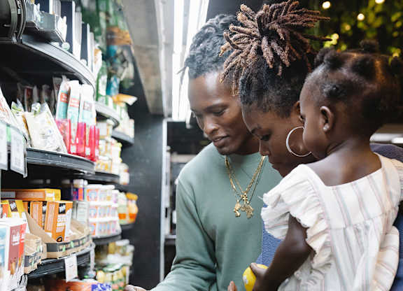 A man and a little girl are shopping in a grocery store.