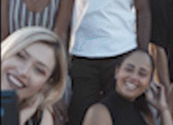 Three people are standing together and taking a selfie.