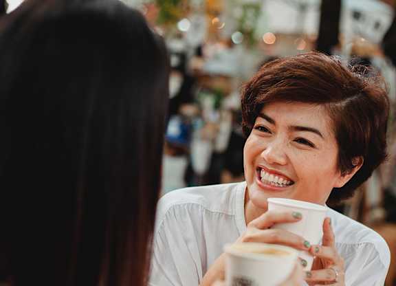 Two women having a conversation over a cup of coffee.