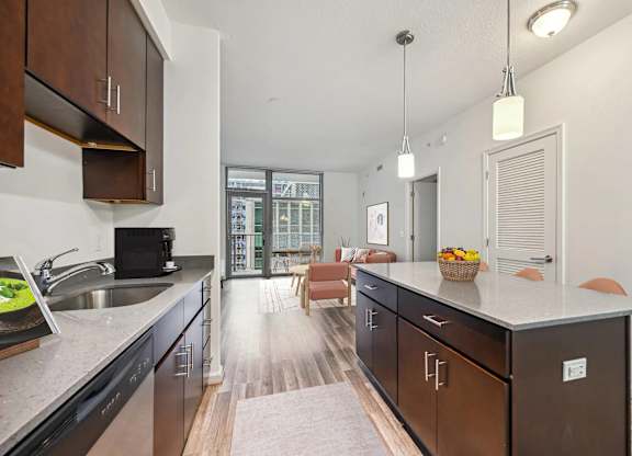 A kitchen with dark wood cabinets and a marble countertop.