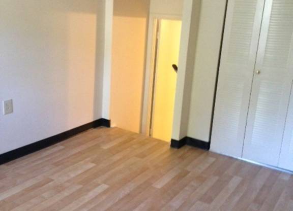 A room with a wooden floor and white walls.
