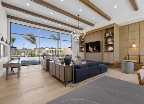 the living room has a large window overlooking the pool and the beachat Westbury Apartments, Rancho Cucamonga, California 