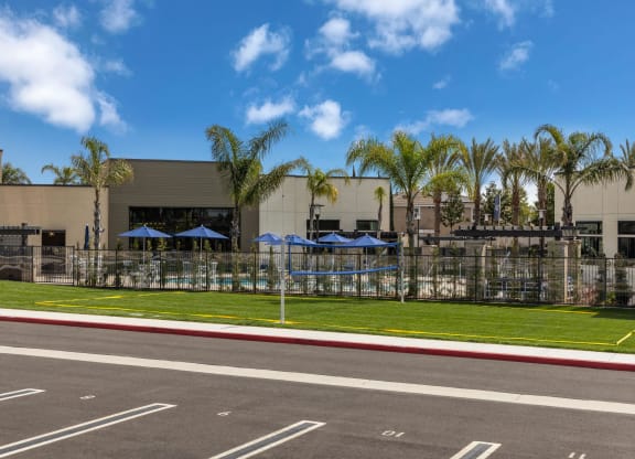 a building with umbrellas and palm trees in front of itat Westbury Apartments, Rancho Cucamonga, CA, 91739