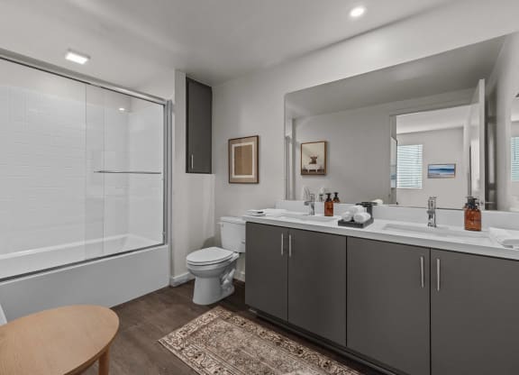 a bathroom with a shower toilet and sink and a mirrorat Westbury Apartments, Rancho Cucamonga, California