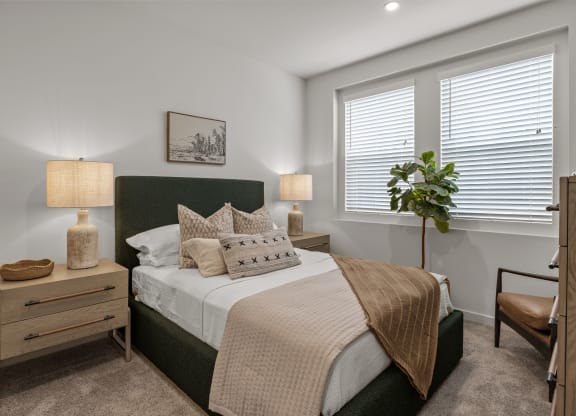 an empty bedroom with a bed and two windowsat Westbury Apartments, Rancho Cucamonga, CA, 91739